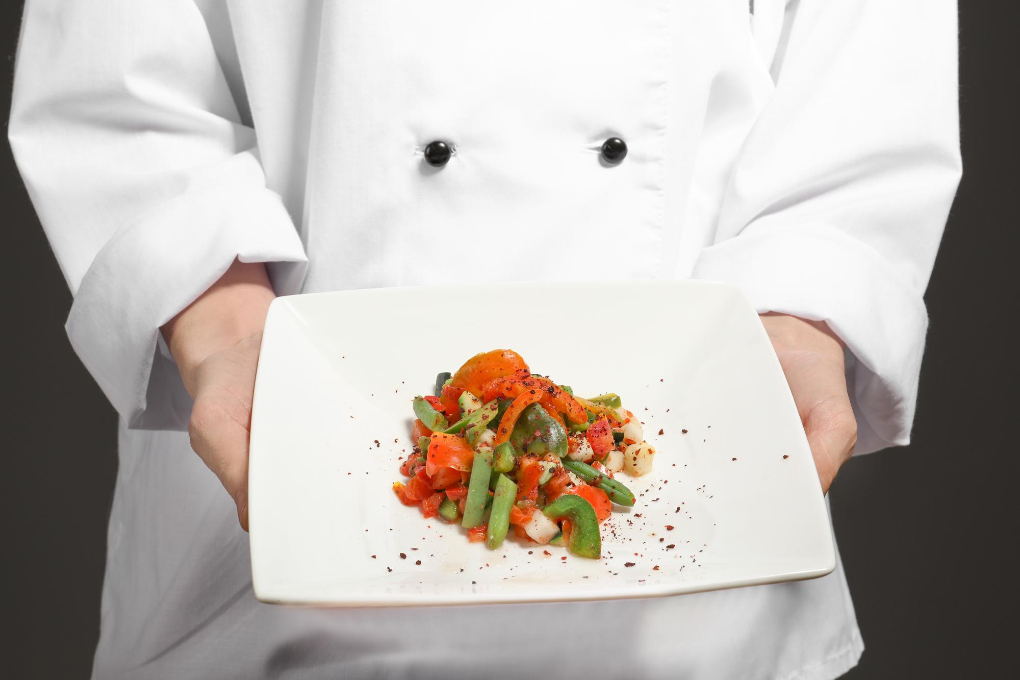 Chef preparing plated dish in warm kitchen